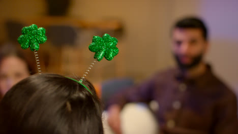 Close-Up-Of-Friends-Dressing-Up-With-Irish-Novelties-And-Props-At-Home-Celebrating-At-St-Patrick's-Day-Party